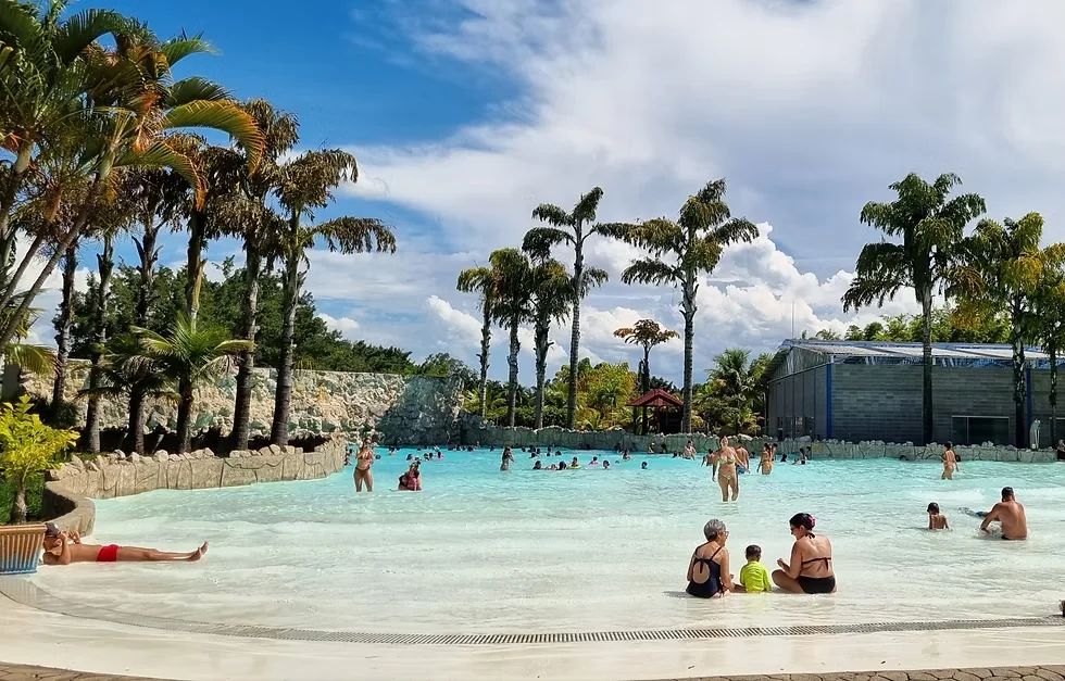 Piscina de ondas do Thermas do Vale cercada de coqueiros, em São José dos Campos
