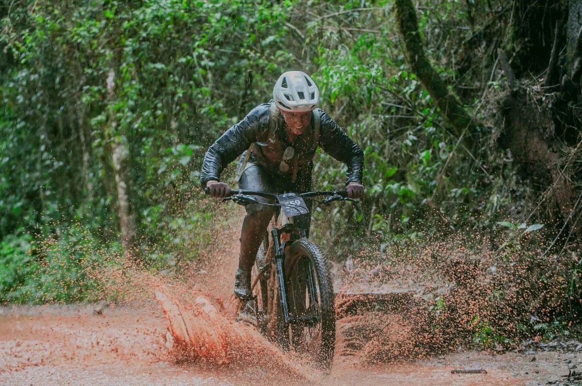 Ciclista de mountain bike numa trilha de terra no meio da mata