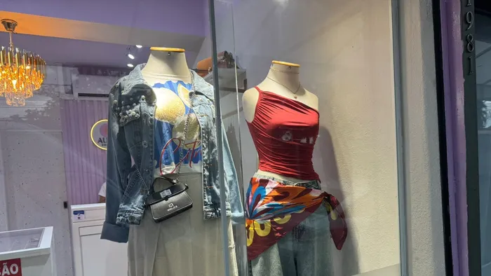 Vitrine da Aura Choice com dois manequins, um de jaqueta jeans e outro de blusa vermelha com lenço estampado