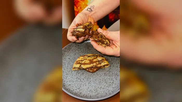 Cookie recheado de chocolate sendo aberto ao meio no Café 3 Irmãos