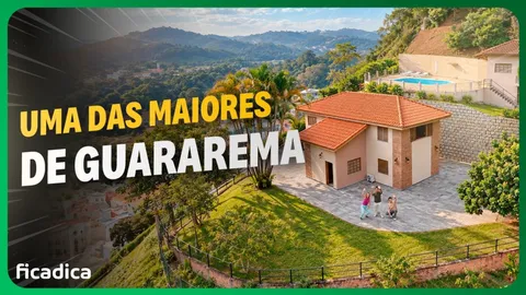 Vista aérea da Caza Villa Bella, casa de telhado laranja com gramado e piscina, nos morros de Guararema