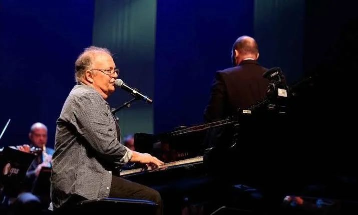 Guilherme Arantes cantando ao piano no palco