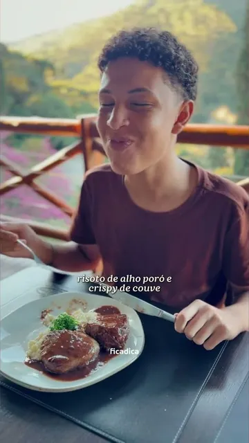 Menino almoçando medalhão com risoto de alho-poró e crispy de couve na varanda do Jardins Restaurante, em Santo Antônio do Pinhal
