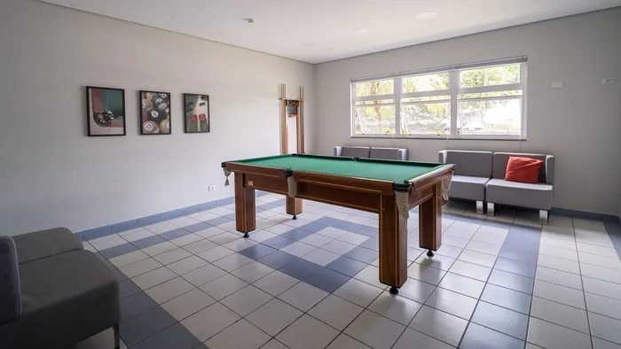 Salão de jogos do hotel com mesa de sinuca e sofás