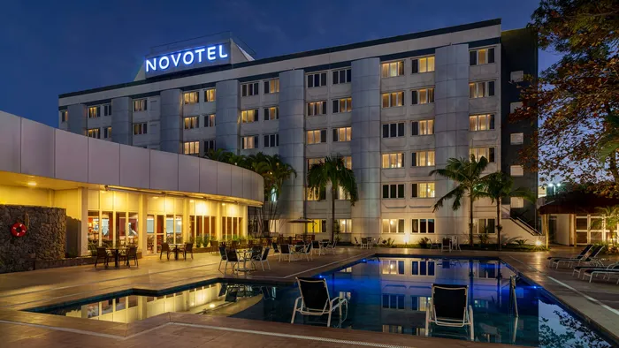 Novotel São José dos Campos à noite, com o prédio e a piscina iluminados