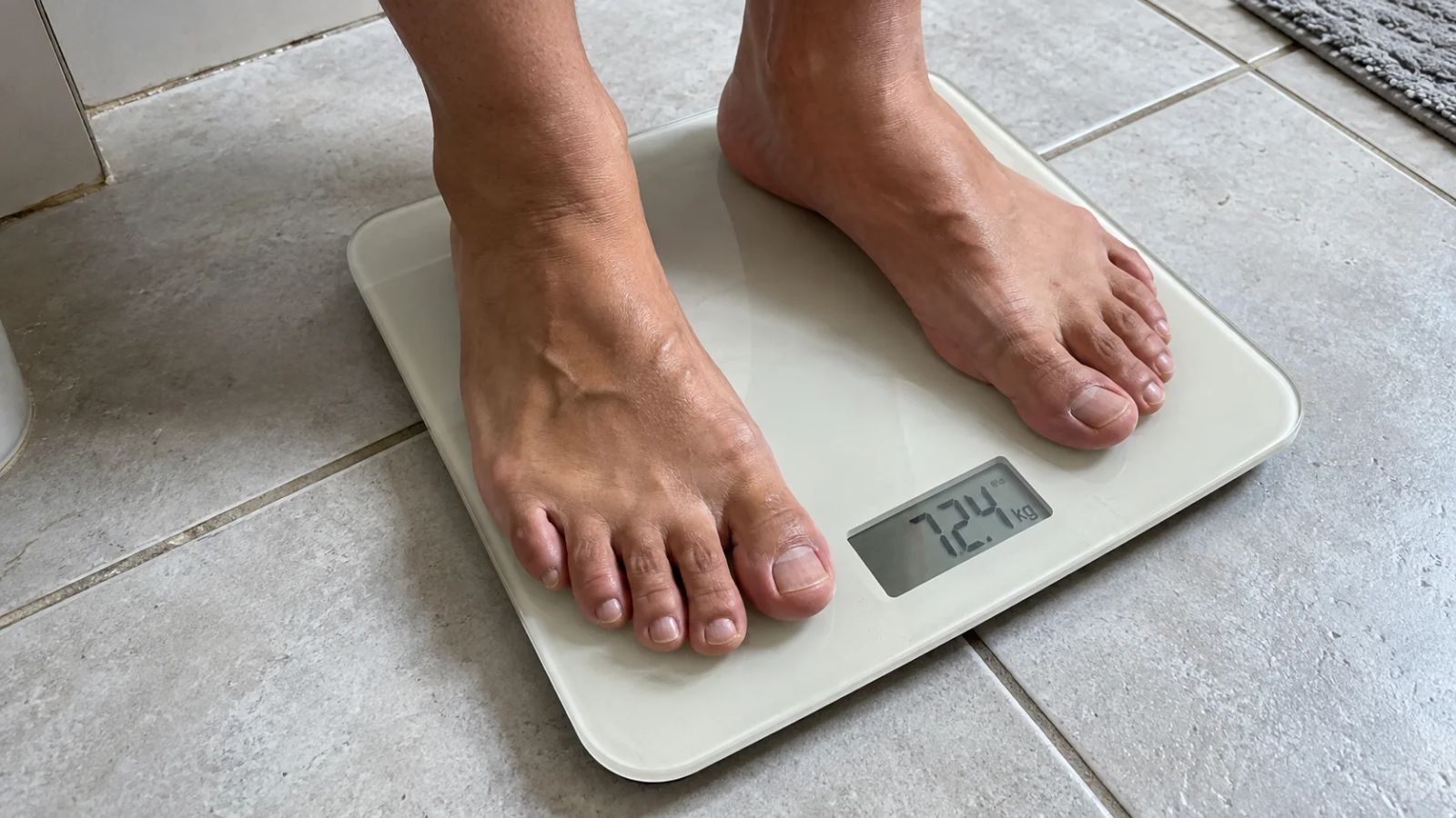 Pés descalços sobre uma balança digital que marca 72,4 kg