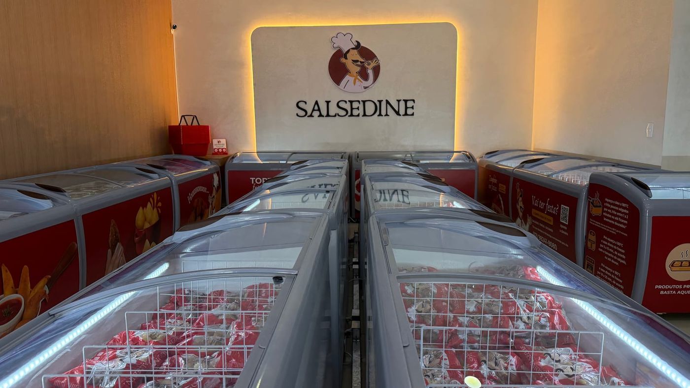 Salão da loja Salsedine com freezers de salgados congelados e o logo da marca na parede