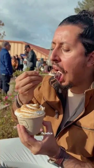 Homem comendo o Santo Merengue, sorvete com merengue maçaricado, no quiosque da Santin Gelato em Campos do Jordão